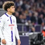 Theo Leoni in het witte tenue van Anderlecht aan de rand van het veld.