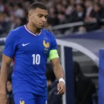 Kylian Mbappé in het tenue van Frankrijk terwijl hij naar de zijlijn wandelt.