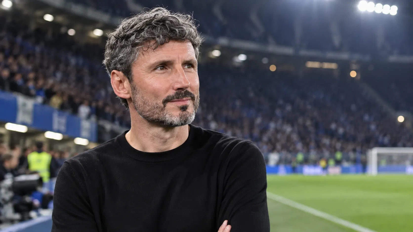 Mark van Bommel in zwarte kleding aan de rand van het veld na een wedstrijd.