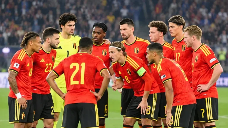 Een groep Belgische spelers in rode nationale tenues op het veld tijdens een wedstrijdmoment.