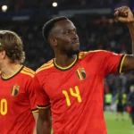 Dodi Lukebakio viert op het veld in het rode tenue van België, naast een ploegmaat.