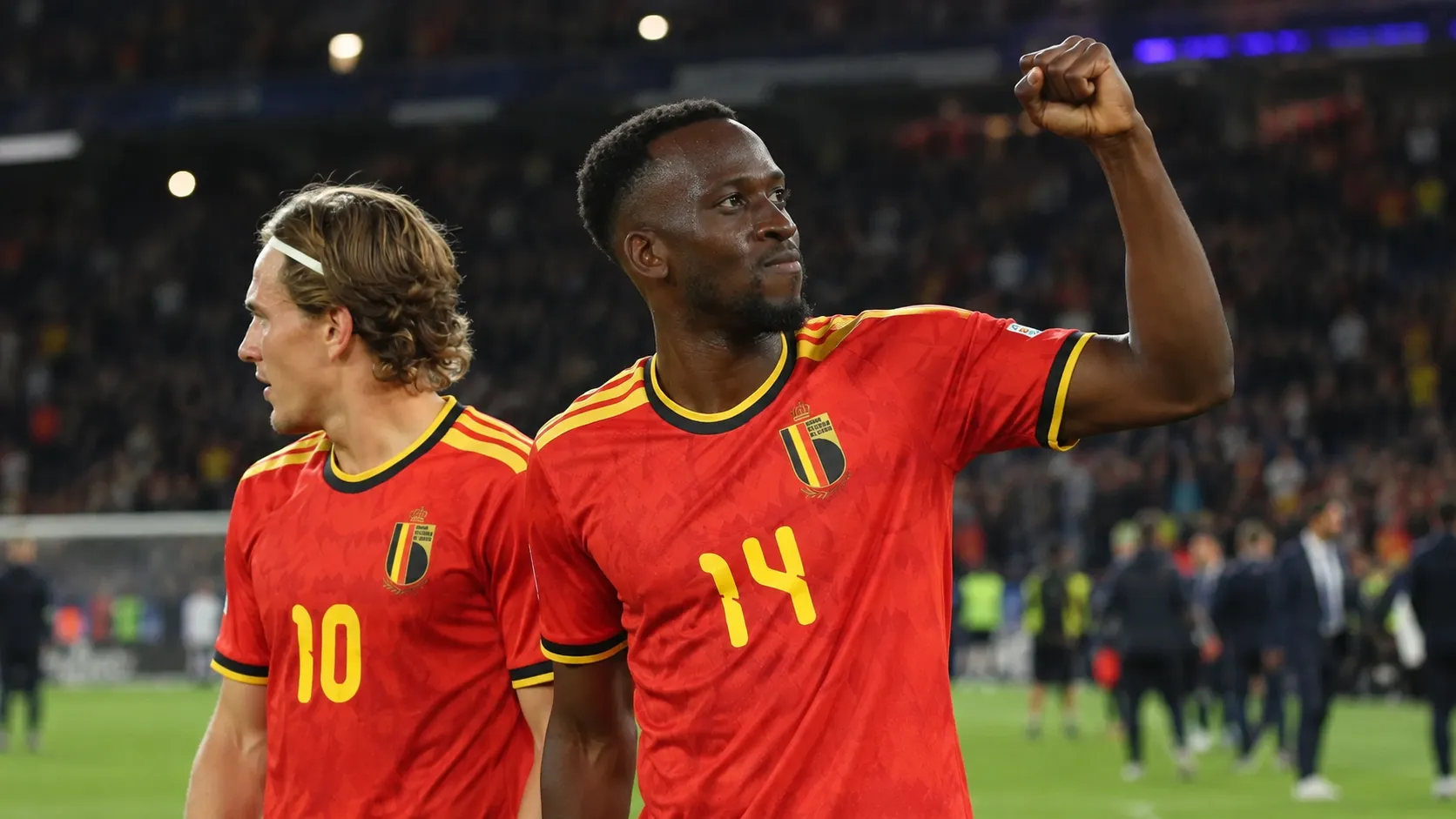 Dodi Lukebakio viert op het veld in het rode tenue van België, naast een ploegmaat.