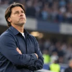 Mauricio Pochettino kijkt peinzend omhoog langs de zijlijn van een stadion.