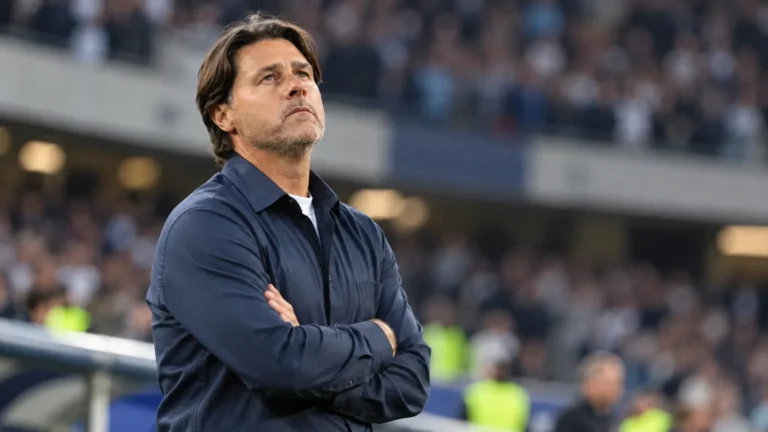Mauricio Pochettino kijkt peinzend omhoog langs de zijlijn van een stadion.