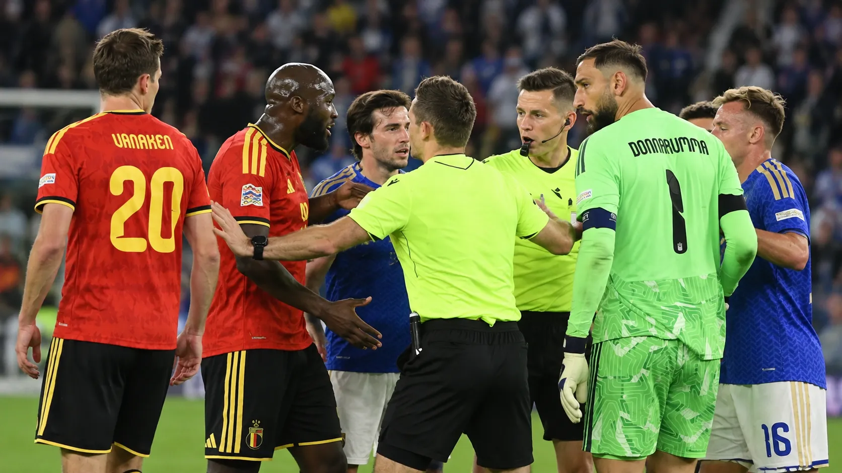 Spelers van België en Italië discussiëren na de wedstrijd terwijl officials tussenbeide komen.