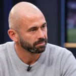 Steven Defour in een grijze trui tijdens een voetbalinterview in een neutrale studiocontext.