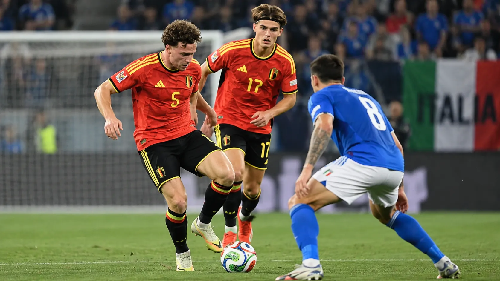 Twee Belgische spelers in rode shirts tijdens een wedstrijdmoment in Italië.