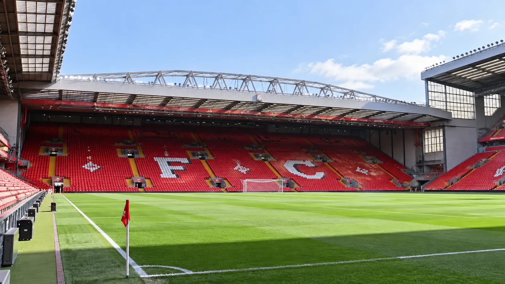 Lege rode tribunes van het stadion van Liverpool met het clubopschrift in de zitplaatsen.