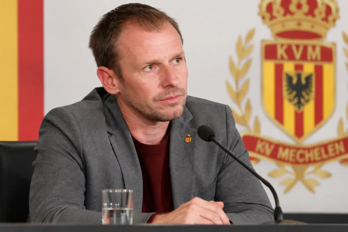 Tom Caluwé zit aan een persmicrofoon tijdens een bijeenkomst van KV Mechelen.