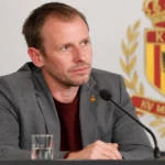 Tom Caluwé zit aan een persmicrofoon tijdens een bijeenkomst van KV Mechelen.