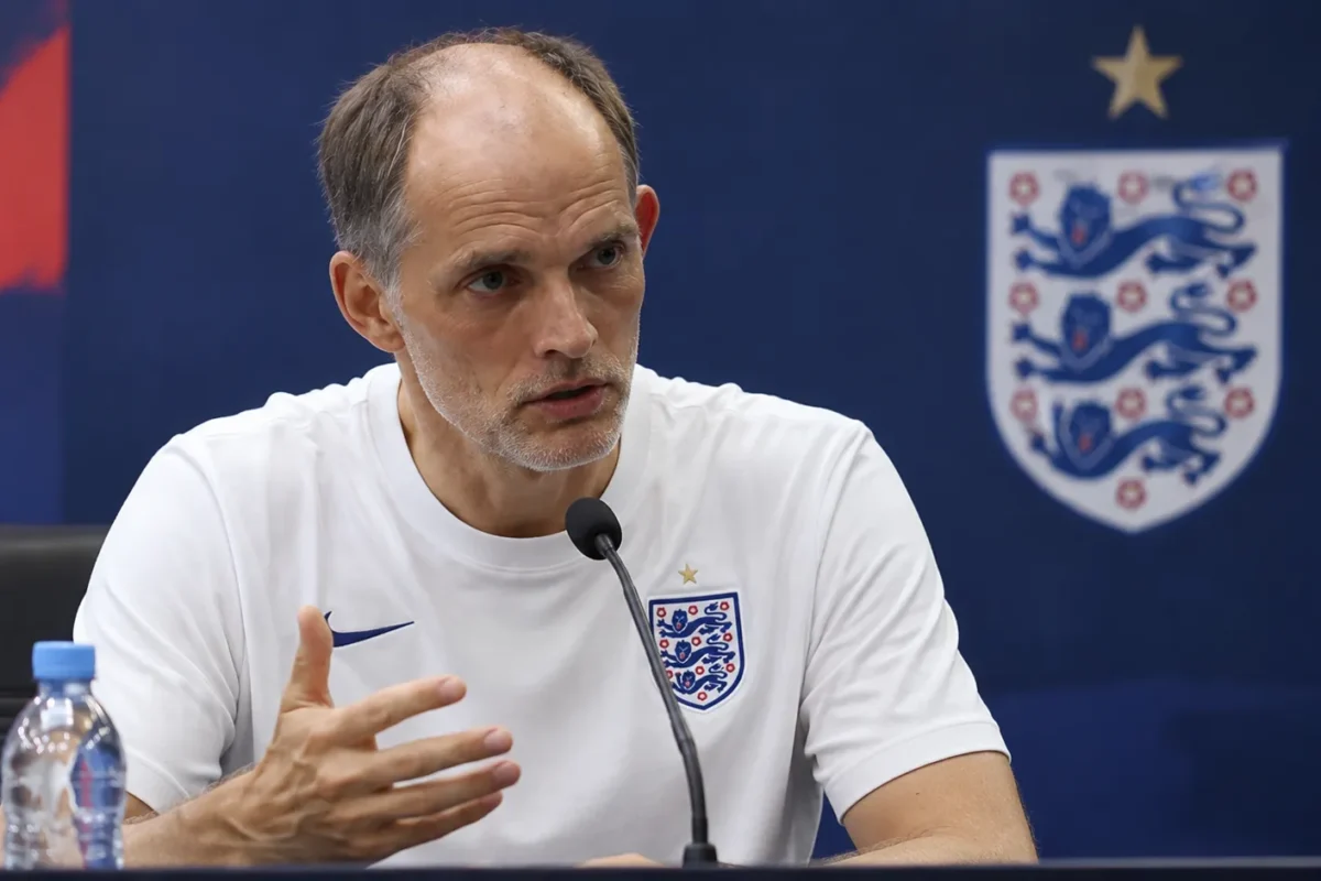 Thomas Tuchel spreekt op een persconferentie van Engeland in een wit trainingstenue.