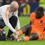 Brian Brobbey krijgt verzorging op het veld in een oranje Nederlands tenue.