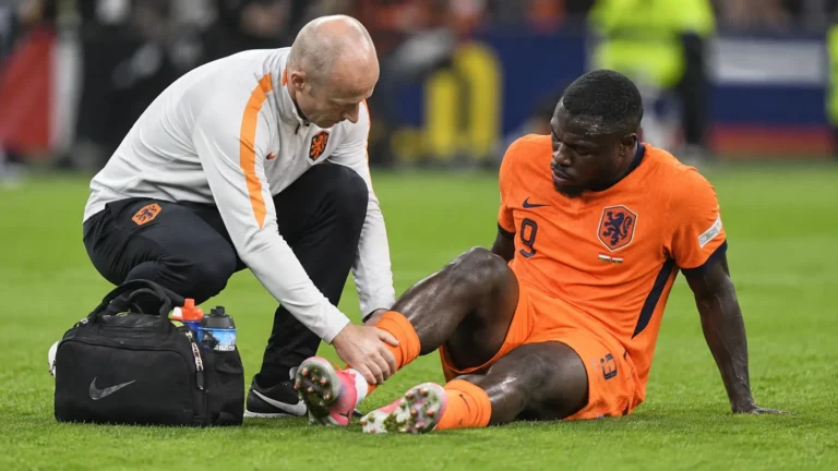 Brian Brobbey krijgt verzorging op het veld in een oranje Nederlands tenue.