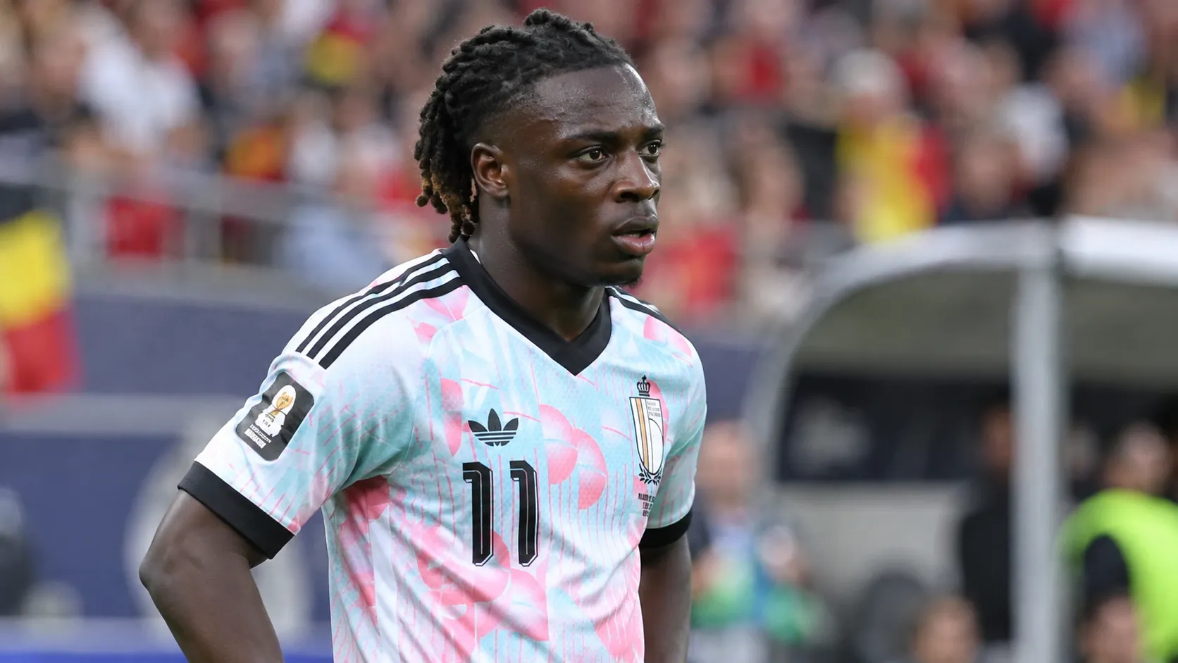 Jérémy Doku in het tenue van de Rode Duivels langs het veld.