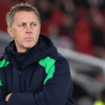 Een Ierse coach in de technische zone van een stadion voor een interland.