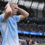 Erling Haaland in het lichtblauwe tenue van Manchester City langs de zijlijn.