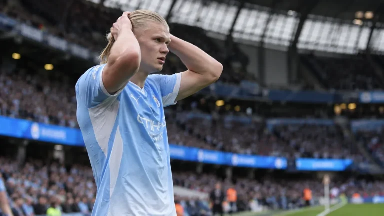 Erling Haaland in het lichtblauwe tenue van Manchester City langs de zijlijn.