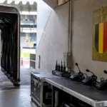 Lege spelerstunnel in het Koning Boudewijnstadion met een Belgische voetbalembleemplaat bij de officiëlenzone.