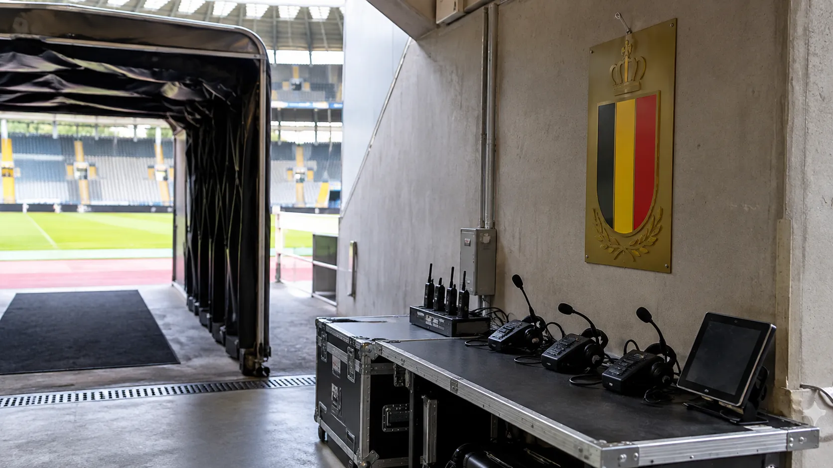 Lege spelerstunnel in het Koning Boudewijnstadion met een Belgische voetbalembleemplaat bij de officiëlenzone.