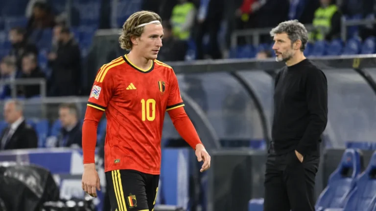 Belgische international in rood nationaal tenue wandelt na de wedstrijd langs de zijlijn.