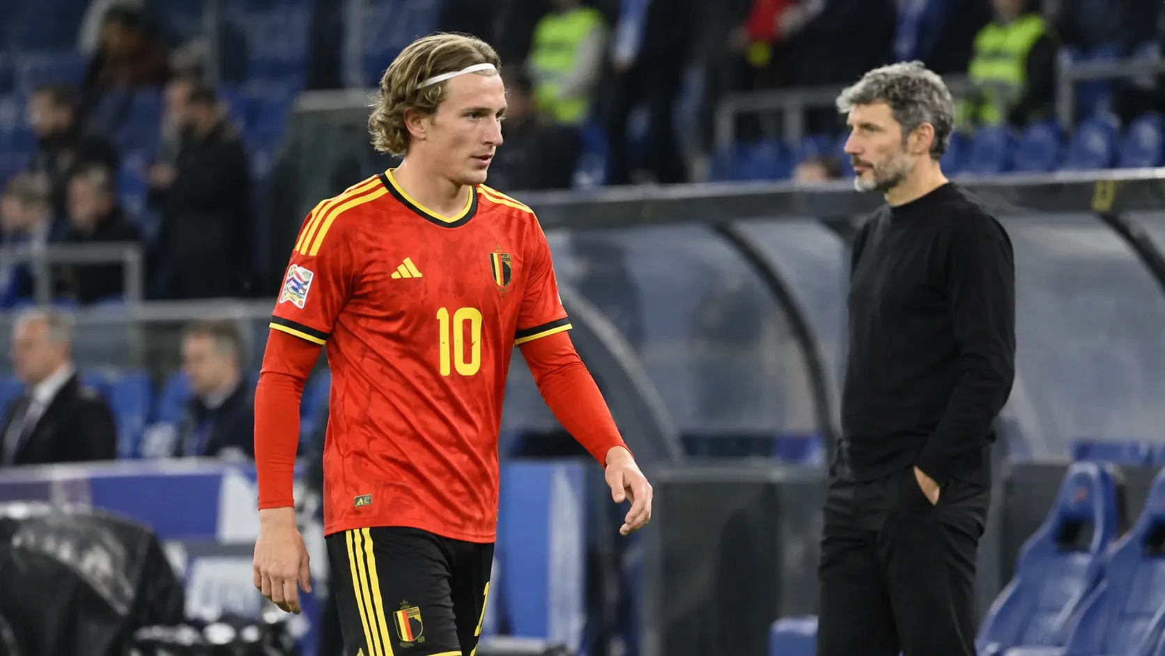 Belgische international in rood nationaal tenue wandelt na de wedstrijd langs de zijlijn.