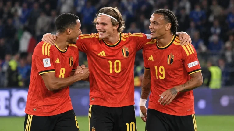 Drie Belgische internationals vieren samen op het veld.