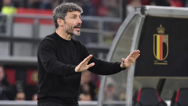 Mark van Bommel geeft aanwijzingen naast het veld, met een subtiel embleem van de Rode Duivels op de dug-out.