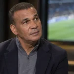 Ruud Gullit tijdens een rustig voetbalgesprek in een professionele binnenruimte.