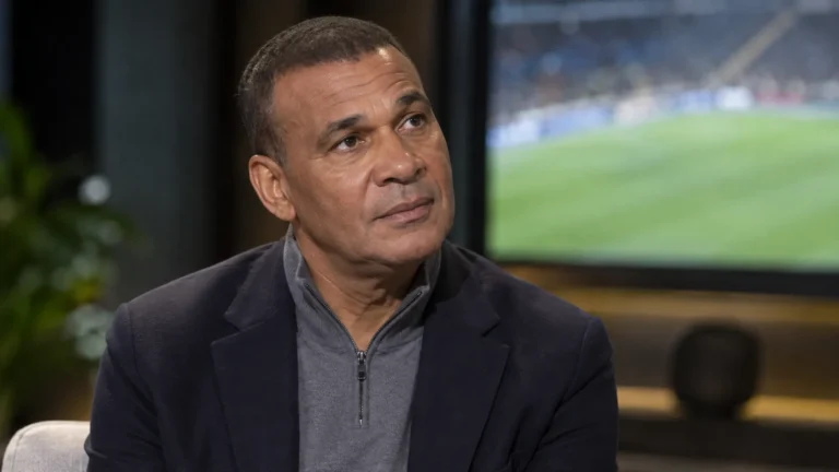 Ruud Gullit tijdens een rustig voetbalgesprek in een professionele binnenruimte.