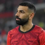 Mohamed Salah in het rode shirt van Egypte in een stadionomgeving.