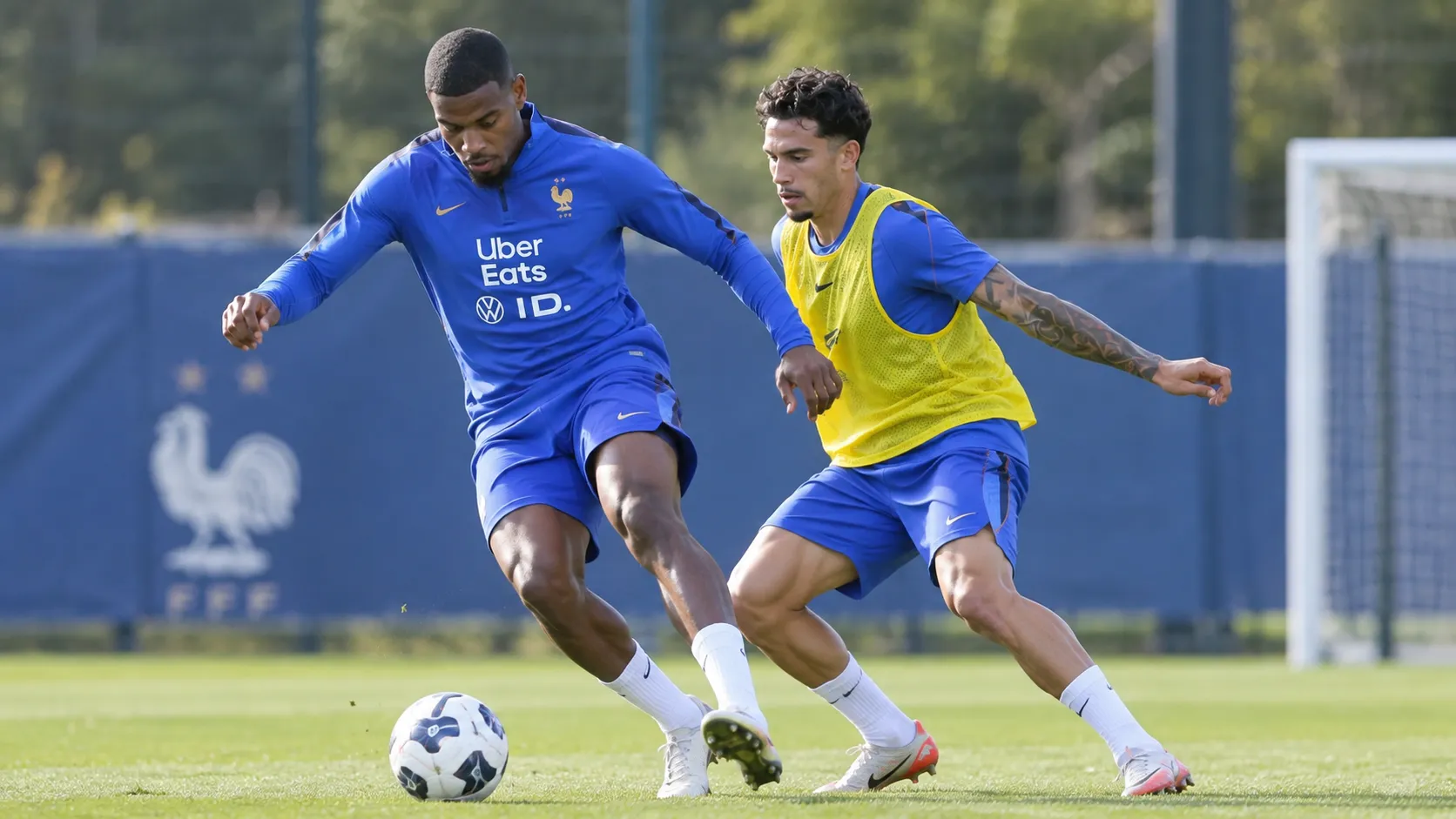 Twee Franse voetballers tijdens een oefenvorm op een trainingsveld.