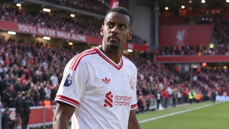 Alexander Isak in een wit Liverpool-shirt aan de rand van het veld.