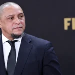 Roberto Carlos in donker pak tijdens een formeel FIFA-voetbalevenement.