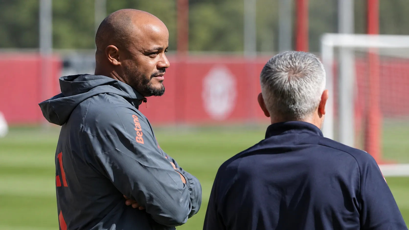 Vincent Kompany in gesprek met een staflid op het trainingsveld van Bayern München.