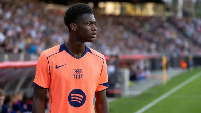 Jesse Bisiwu in het oranje shirt van FC Barcelona bij een wedstrijdmoment langs de zijlijn.