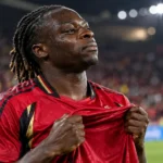 Jérémy Doku in het rode shirt van de Belgische nationale ploeg op het veld.
