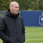 Zinedine Zidane staat als bondscoach naast een Frans oefenveld.