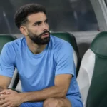 Rayan Aït-Nouri zit alleen op de bank van Algerije in neutrale sportkleding.