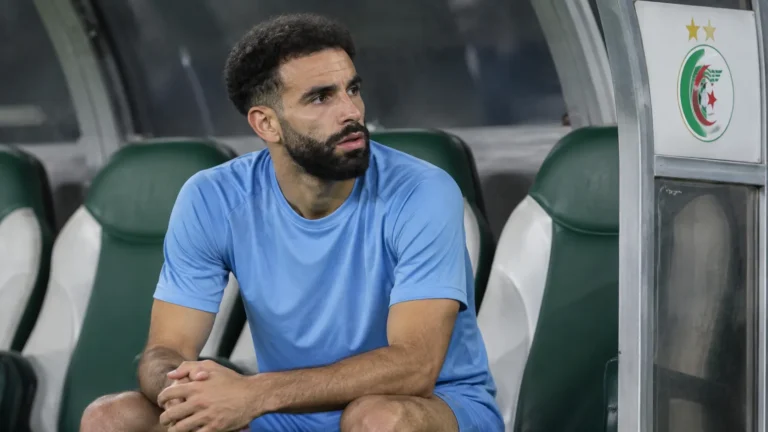 Rayan Aït-Nouri zit alleen op de bank van Algerije in neutrale sportkleding.