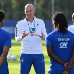 Zinédine Zidane spreekt Franse spelers toe tijdens een training op het grasveld.
