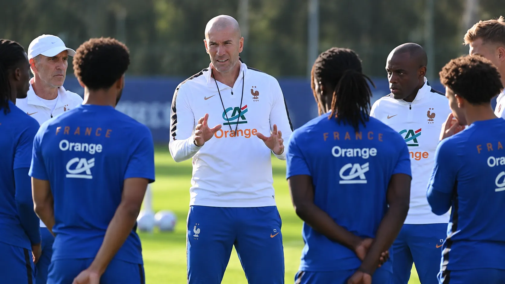 Zinédine Zidane spreekt Franse spelers toe tijdens een training op het grasveld.