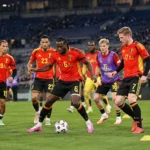 Een groep Belgische spelers in rode nationale tenues tijdens de opwarming in het stadion.