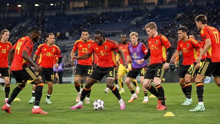 Een groep Belgische spelers in rode nationale tenues tijdens de opwarming in het stadion.