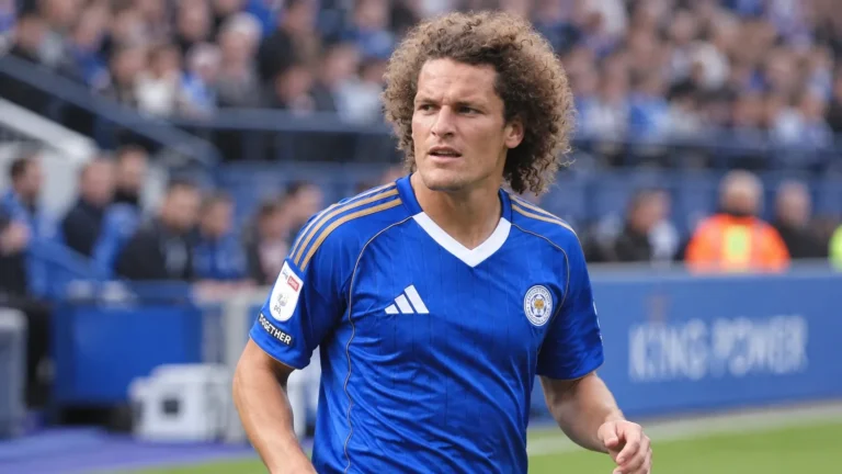 Wout Faes in het blauwe shirt van Leicester City langs de rand van het veld.