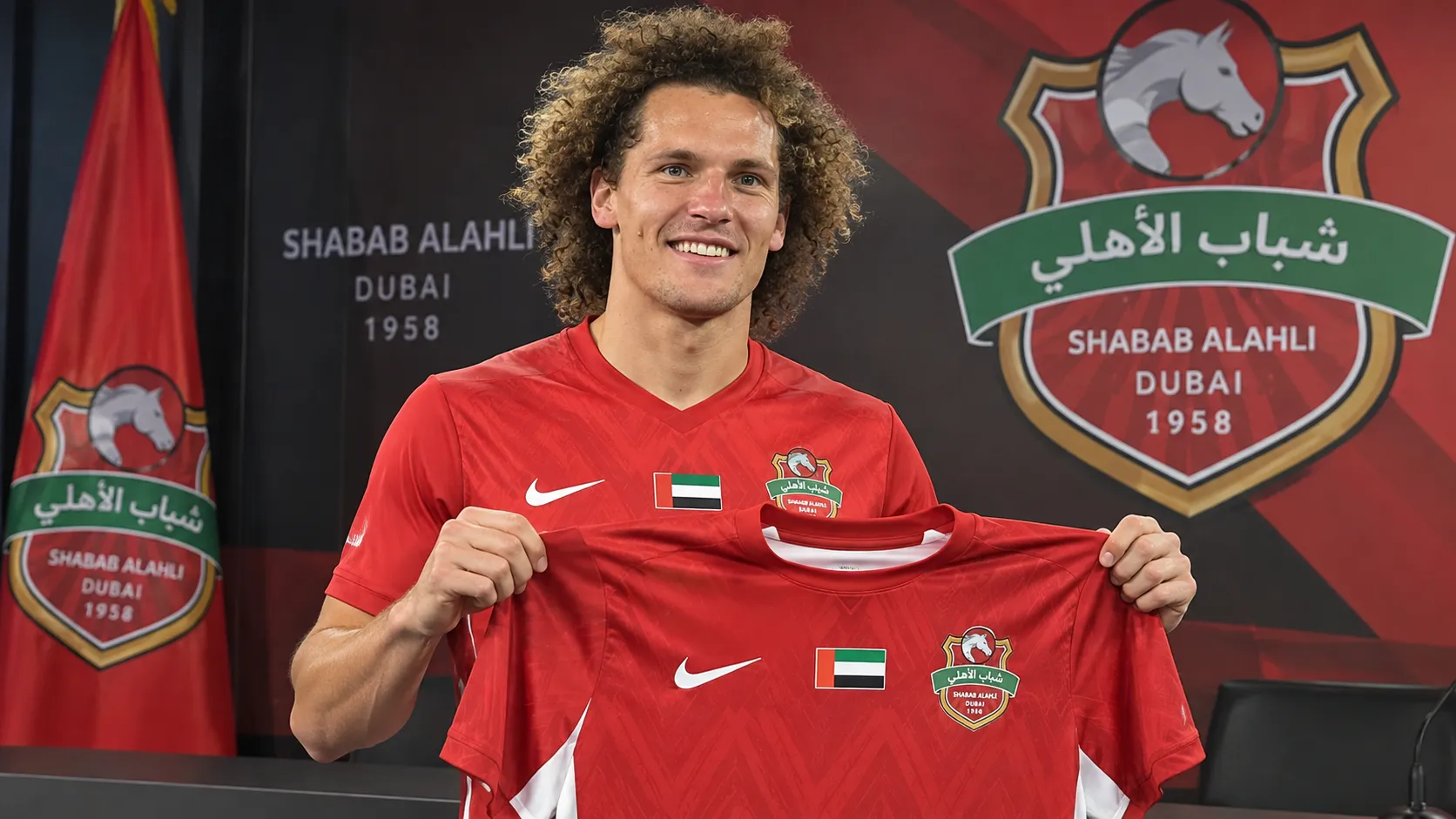 Wout Faes toont het shirt van Shabab Al-Ahli tijdens zijn officiƫle voorstelling.