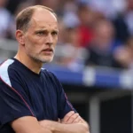 Thomas Tuchel staat geconcentreerd langs de zijlijn van een internationaal stadion.