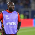 Romelu Lukaku tijdens een opwarming in een stadion met een paarse UEFA Nations League-bib.