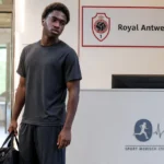 Bahmed Deuff in neutrale sportkleding bij de inkom van een sportmedisch centrum met een Antwerp-verwijzing.