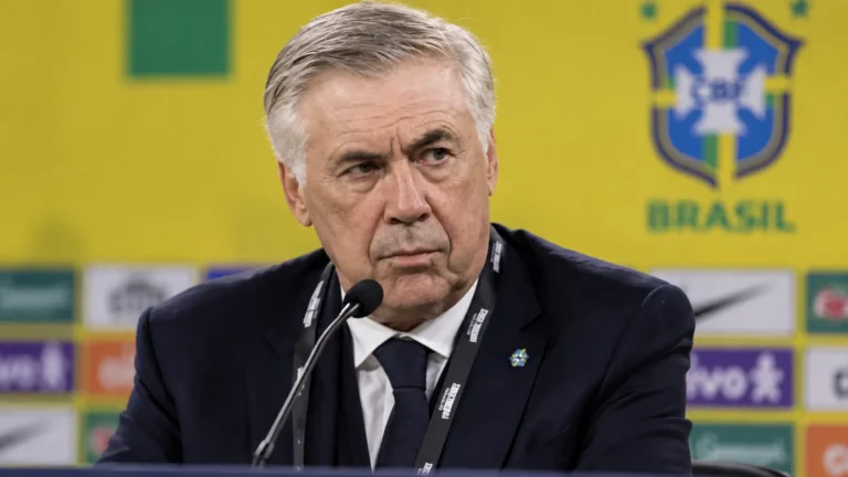 Carlo Ancelotti tijdens een persmoment in een donkere outfit.