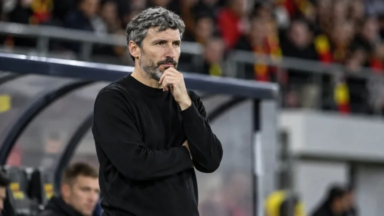 Mark van Bommel in zwarte trui langs de zijlijn bij een interland van België.
